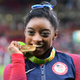 Simone Biles celebrates with her gold medal after the women’s individual all-around final of the Rio 2016 Olympic Games in Rio de Janeiro on Aug. 11, 2016.
EMMANUEL DUNAND/AFP/Getty Images